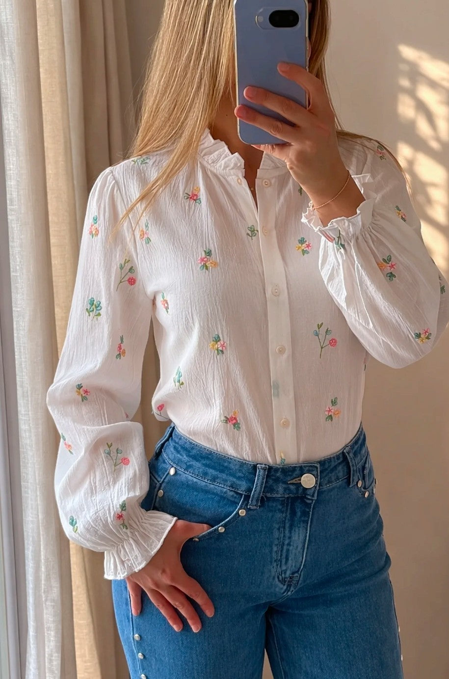 Mujer con blusa blanca con flores bordadas de colores de Leo & Magnolia