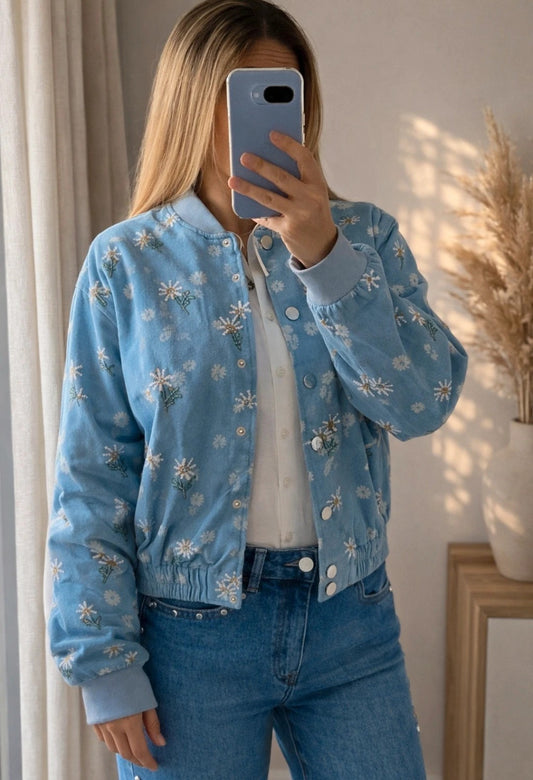 Mujer con bomber vaquera azul claro con margaritas bordadas de Leo & Magnolia
