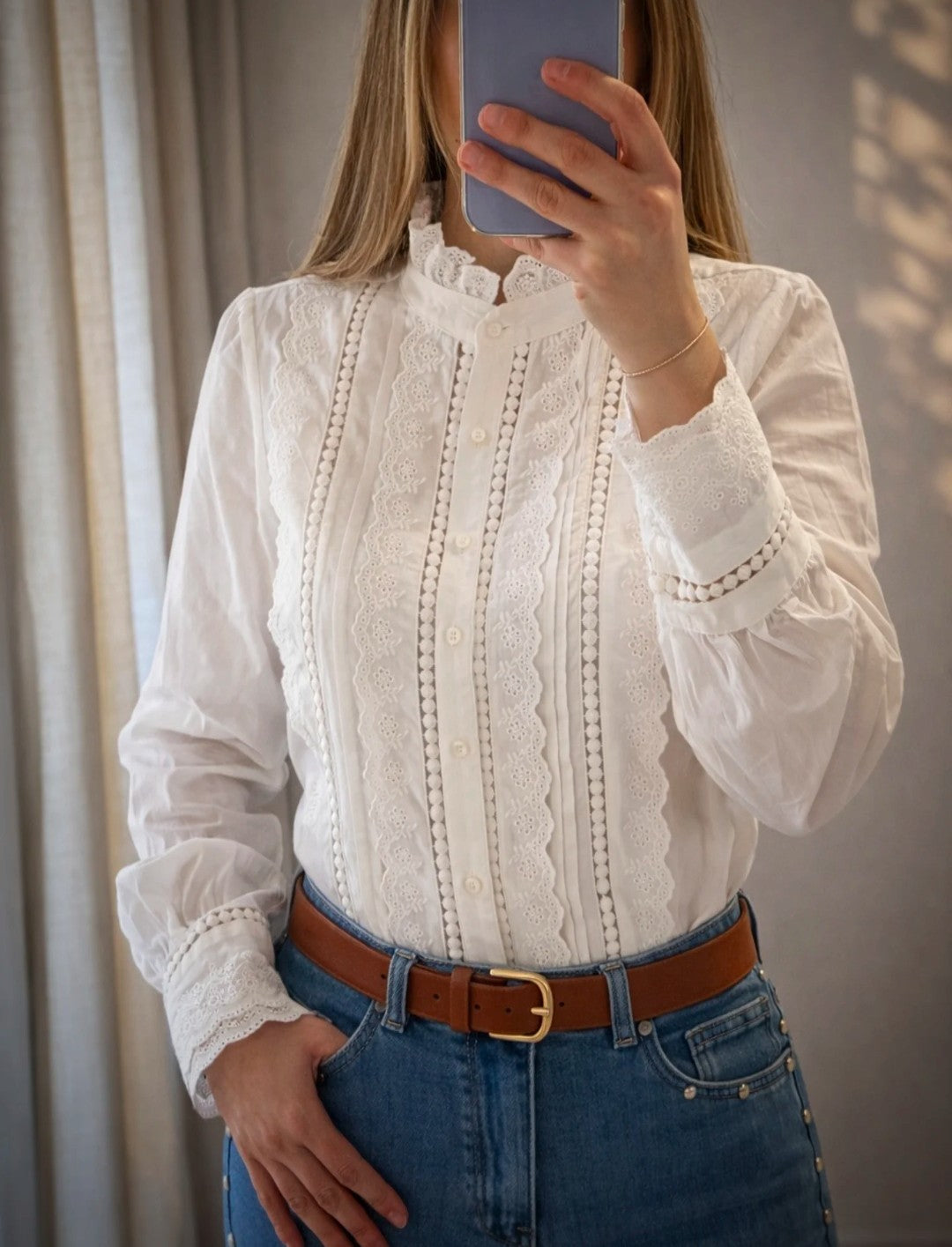 Mujer con blusa blanca con encaje y bordados románticos de Leo & Magnolia