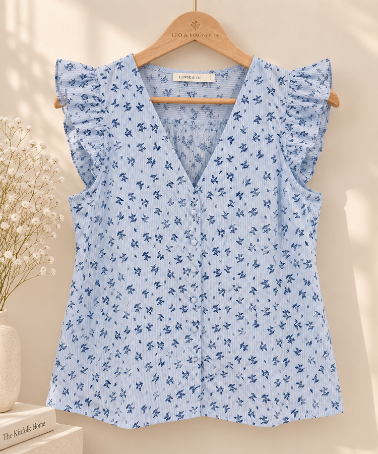 Blusa mujer azul claro Blusa de mujer azul claro con rayas y estampado floral azul colgada en percha