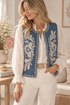 chaqueta de denim bordadoChaleco vaquero azul claro bordado floral combinado con blusa blanca de mujer