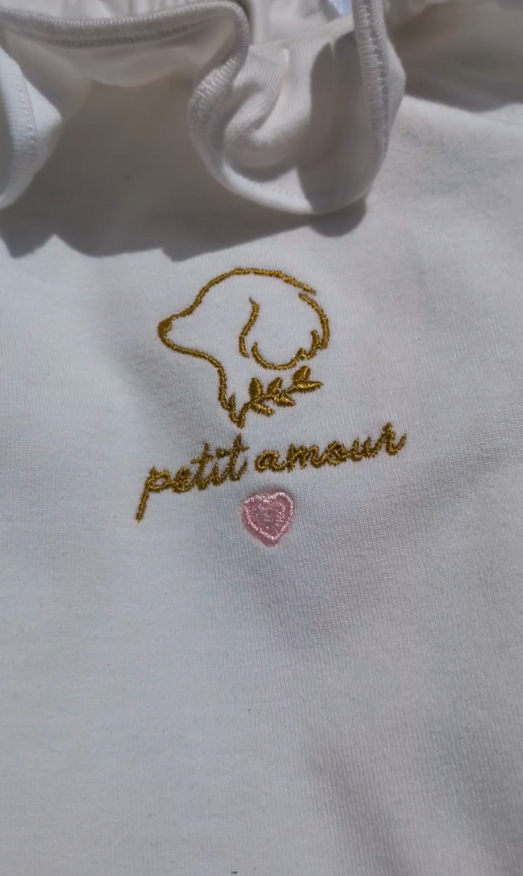 Detalle del logo Petit Amour bordado artesanalmente a mano en el conjunto Rosé para bebé | Leo & Magnolia Conjunto Ranita Alma Body Camille Petit Amour