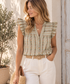Mujer con blusa floral verde salvia con volantes y pantalón en tono neutro | Leo & Magnolia