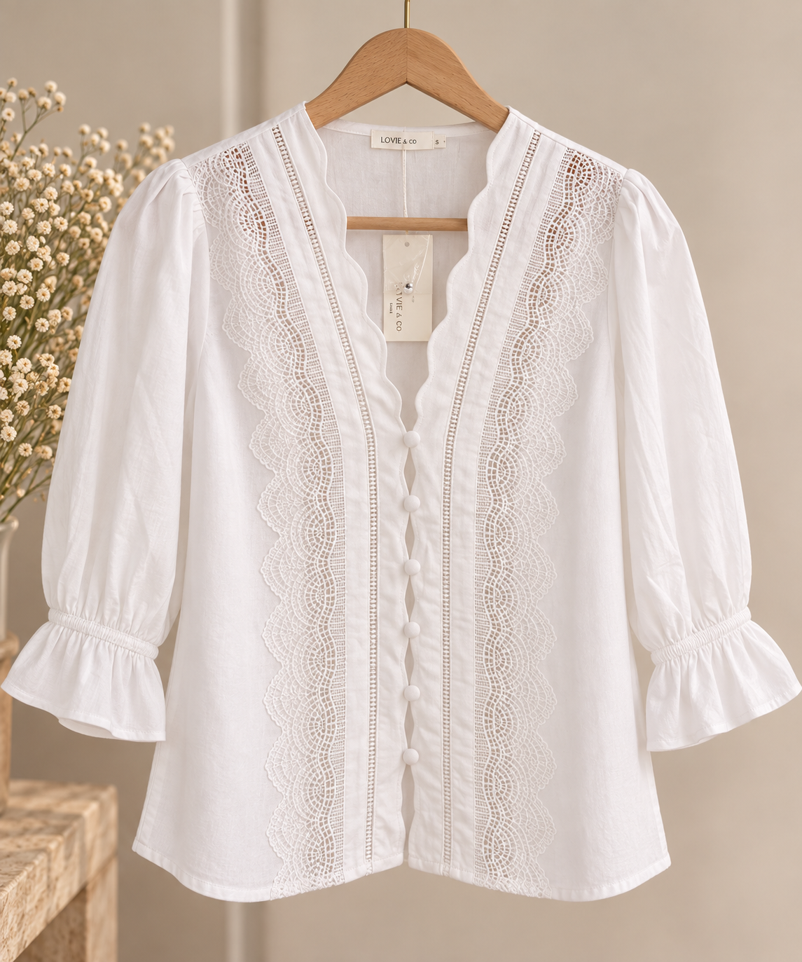 Blusa blanca con encaje Blusa blanca de manga tres cuartos con detalles de encaje, volantes y botones forrados