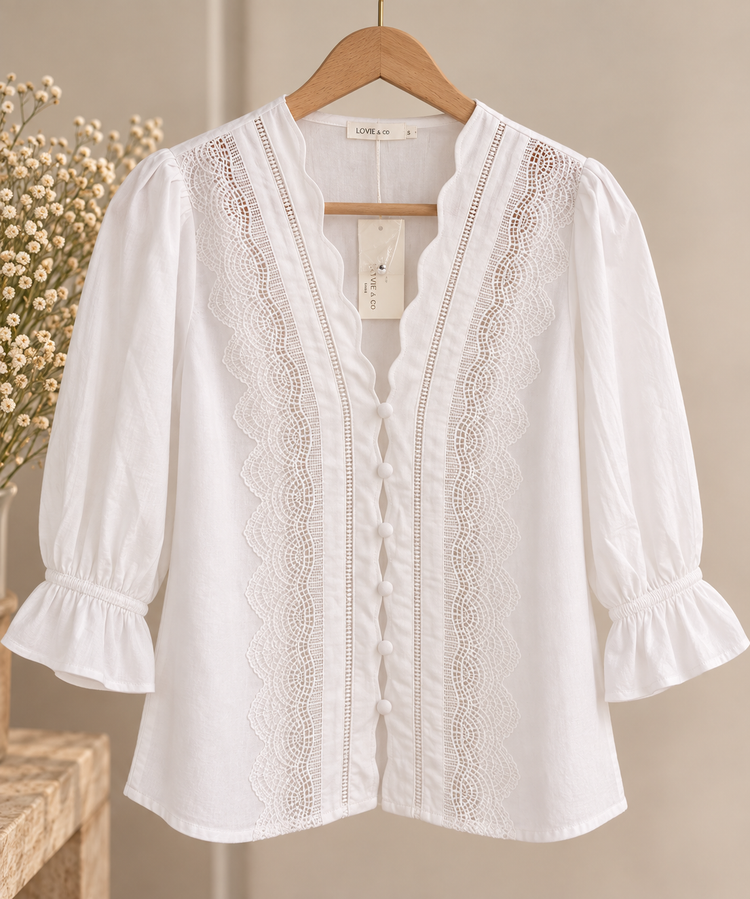 Blusa blanca con encaje Blusa blanca de manga tres cuartos con detalles de encaje, volantes y botones forrados
