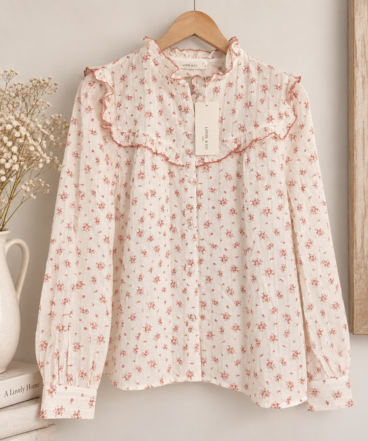blusa floral de algodón Soreya Blusa de algodón color marfil con estampado floral en rosa empolvado, cuello y volantes decorativos.