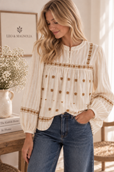 Mujer con blusa bordada de gasa de algodón marfil y pantalón vaquero 