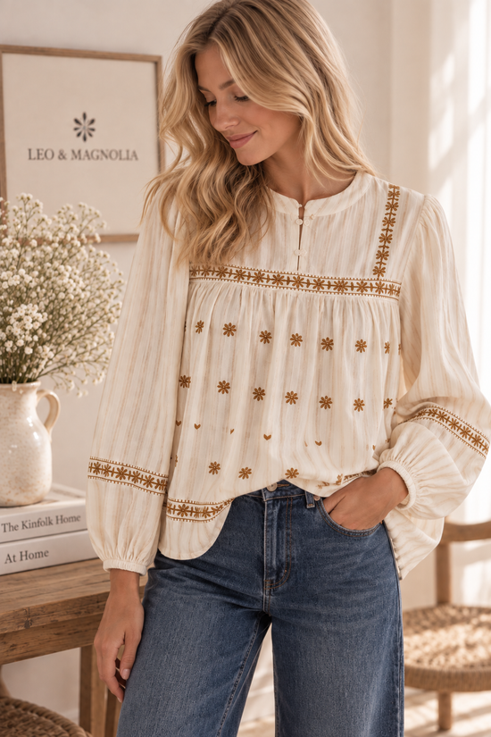 Mujer con blusa bordada de gasa de algodón marfil y pantalón vaquero 